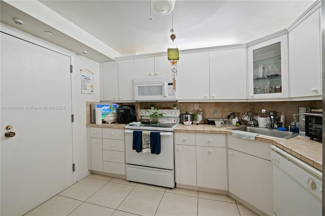 kitchen with white appliances, backsplash, sink, and white cabinets