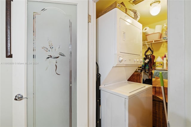 clothes washing area with stacked washer / dryer