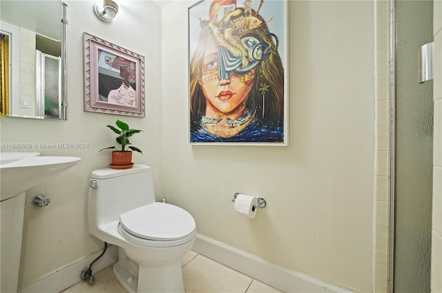 bathroom with tile patterned flooring, toilet, and a shower with door