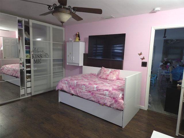 bedroom with dark hardwood / wood-style flooring and ceiling fan