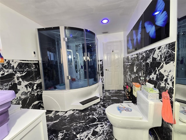 bathroom featuring a shower, tile walls, and toilet