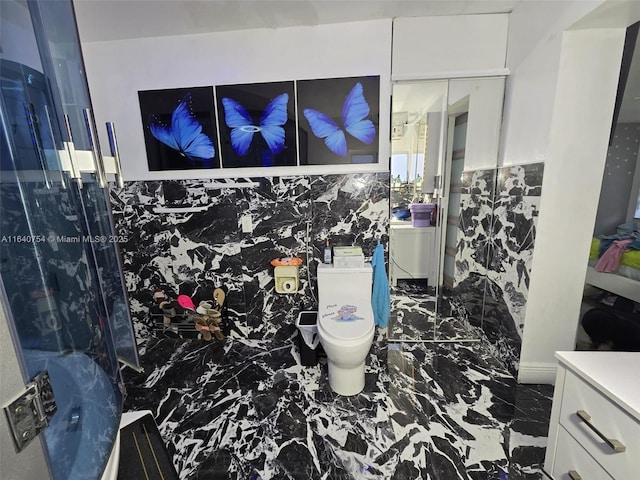 details with vanity, an enclosed shower, and toilet