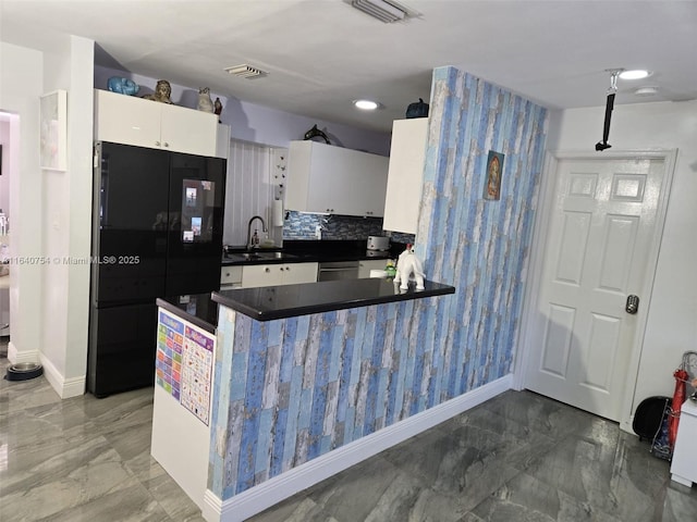 kitchen featuring sink, black refrigerator, stainless steel dishwasher, decorative backsplash, and white cabinets