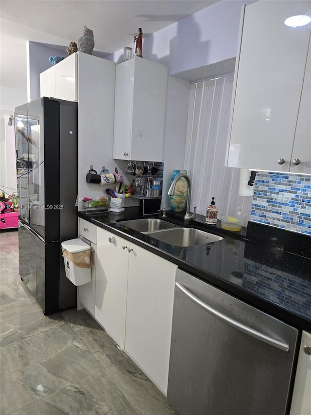 kitchen with sink, dark stone countertops, white cabinets, decorative backsplash, and stainless steel dishwasher