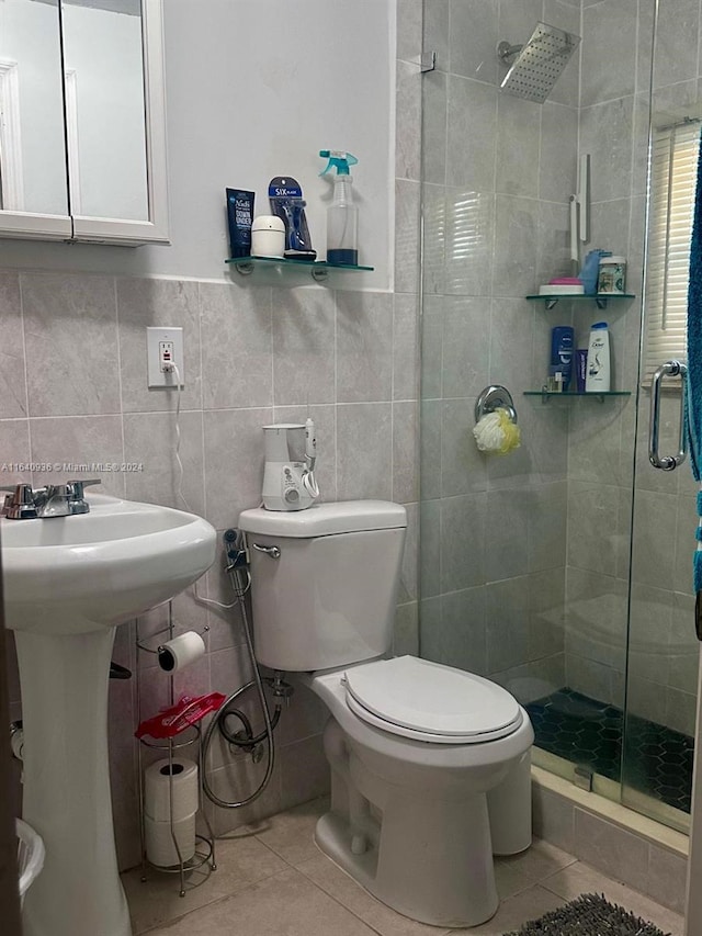 bathroom featuring tile patterned flooring, tile walls, toilet, and walk in shower