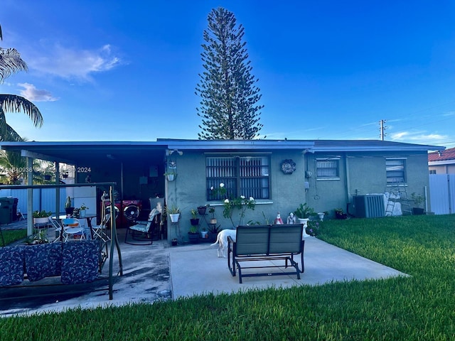 back of house featuring a lawn, cooling unit, a patio area, and a carport