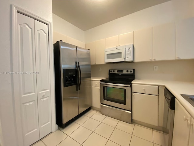 kitchen with light tile patterned floors, white cabinets, and stainless steel appliances