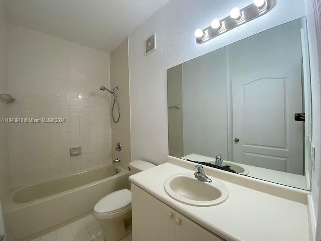 full bathroom featuring tile patterned floors, tiled shower / bath, vanity, and toilet