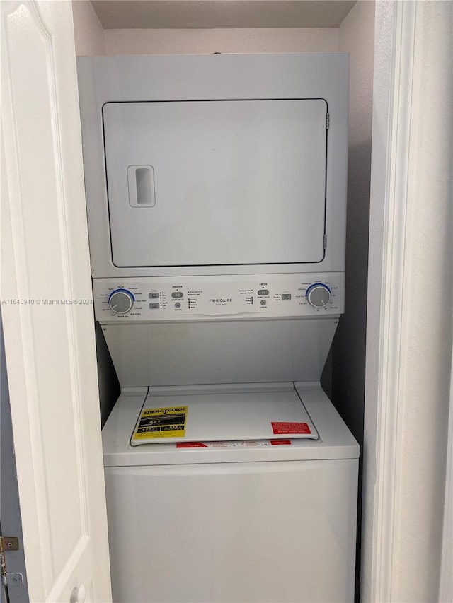 clothes washing area featuring stacked washer / dryer