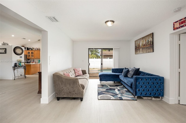 living room featuring lofted ceiling, hardwood / wood-style floors, and a textured ceiling