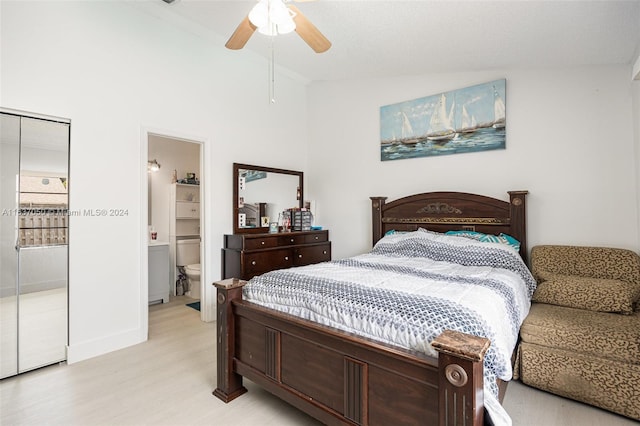 bedroom featuring light hardwood / wood-style flooring, ensuite bathroom, lofted ceiling, and ceiling fan