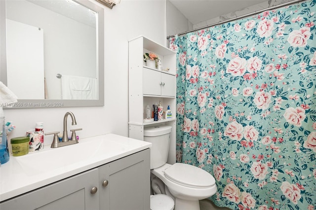 bathroom with vanity, a shower with shower curtain, and toilet