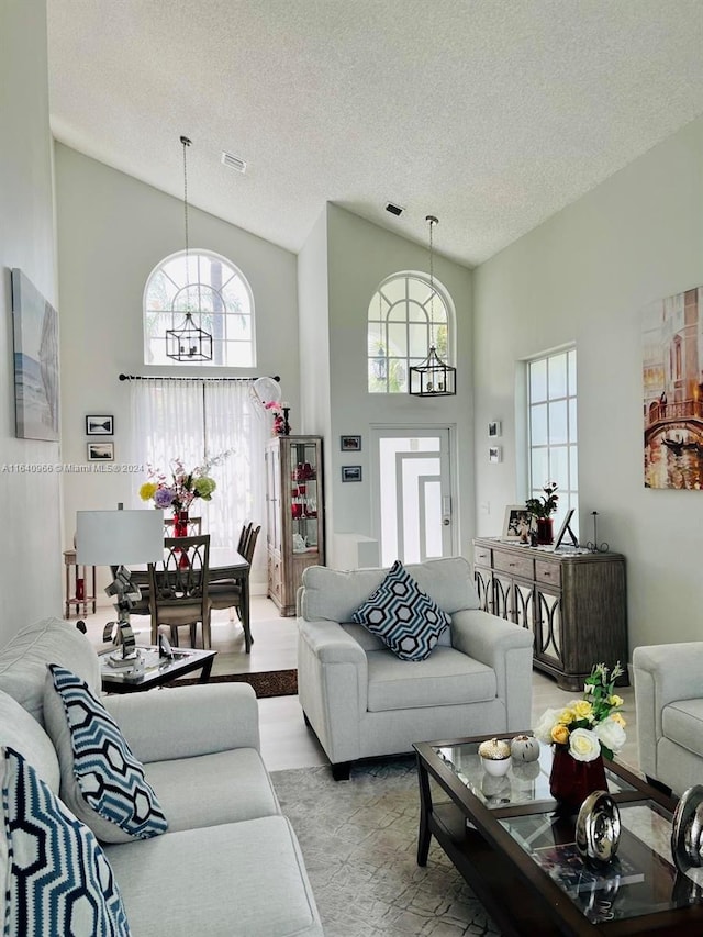 living room with high vaulted ceiling and a textured ceiling