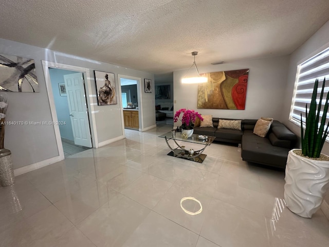 living room featuring light tile patterned flooring and a textured ceiling