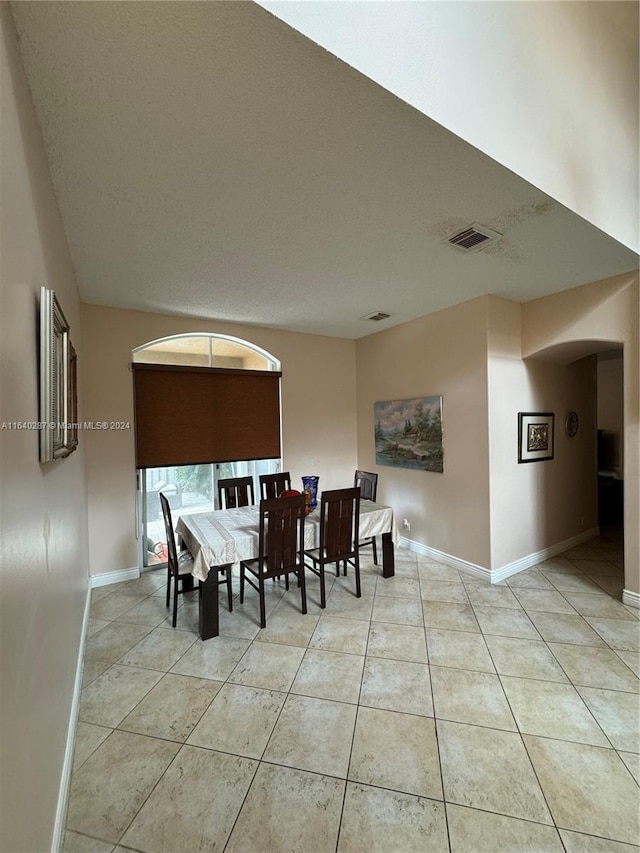 tiled dining area with a textured ceiling