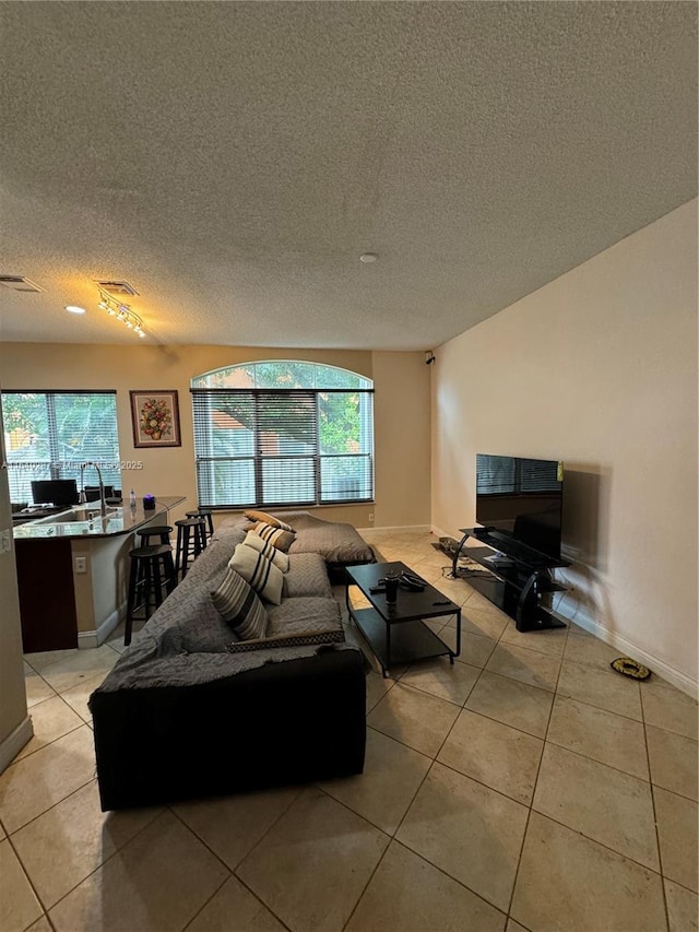 living room with a textured ceiling and light tile patterned flooring