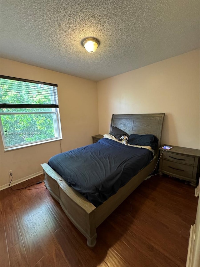 bedroom featuring dark hardwood / wood-style floors and a textured ceiling