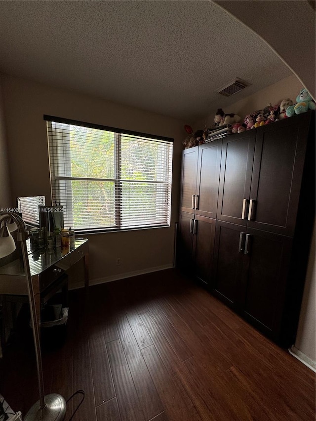 interior space with dark hardwood / wood-style floors and a textured ceiling