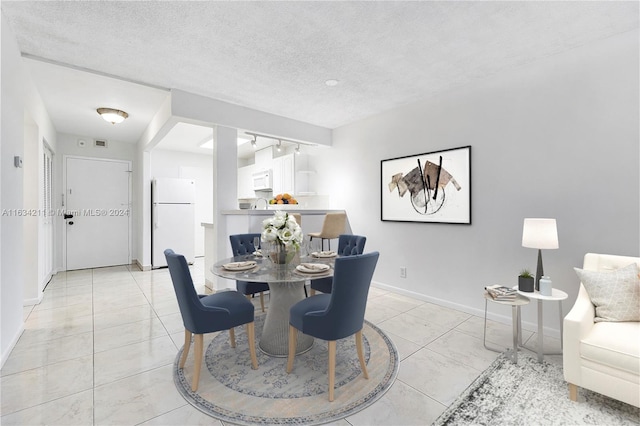 dining space with a textured ceiling