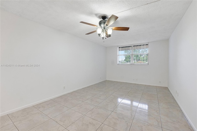 tiled spare room with ceiling fan and a textured ceiling