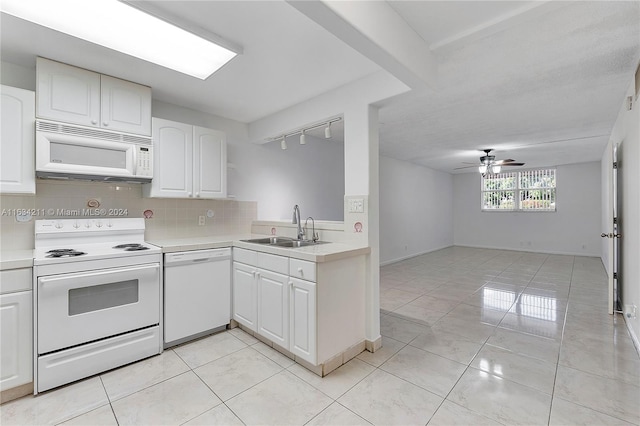 kitchen featuring white appliances, white cabinets, sink, tasteful backsplash, and light tile patterned flooring