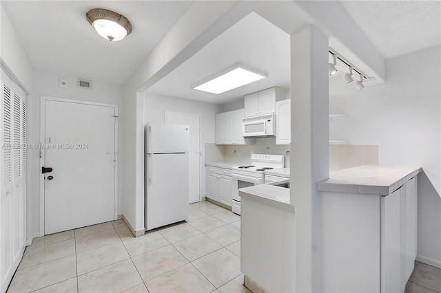 kitchen featuring white cabinets, light tile patterned flooring, white appliances, and track lighting