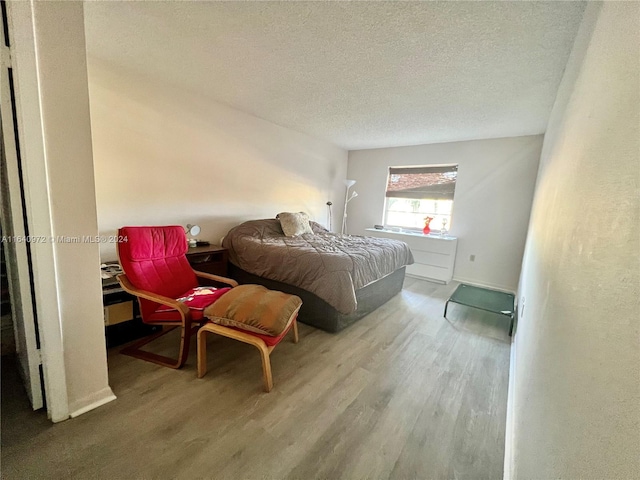 bedroom featuring hardwood / wood-style floors and a textured ceiling