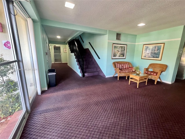 corridor with a textured ceiling and carpet flooring