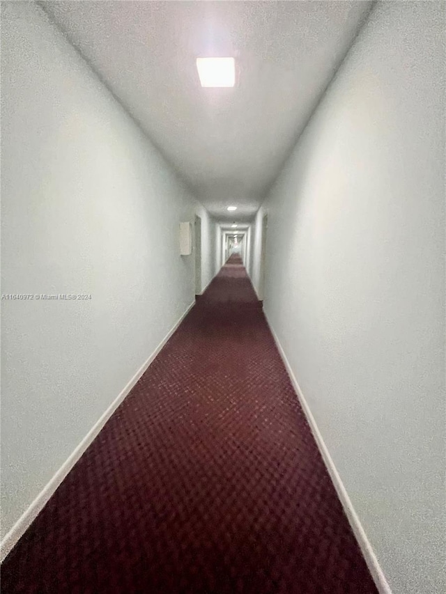 hallway with a textured ceiling and carpet