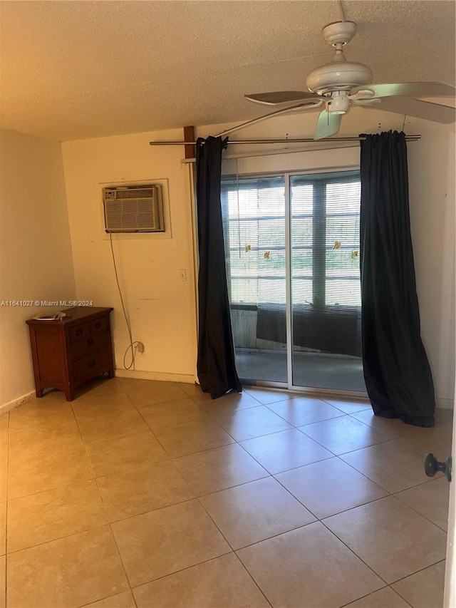 tiled spare room with ceiling fan, a textured ceiling, and a wall unit AC