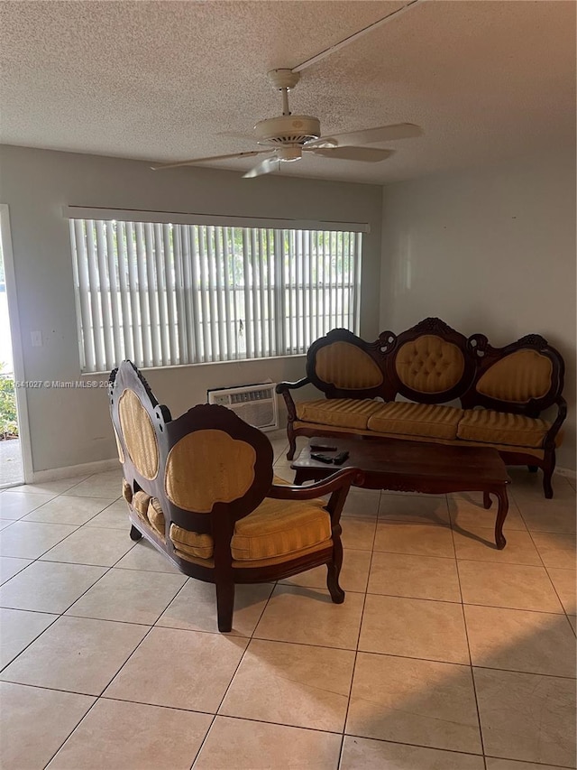 living room with light tile patterned floors, ceiling fan, a textured ceiling, and a healthy amount of sunlight