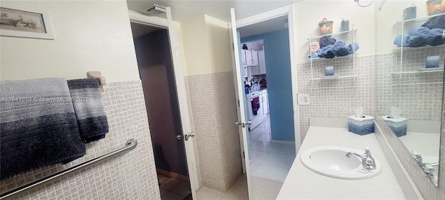 bathroom featuring tile walls, tile patterned floors, and vanity