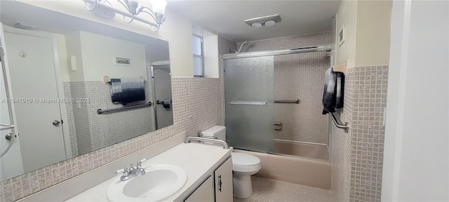 full bathroom with toilet, bath / shower combo with glass door, tile walls, and vanity