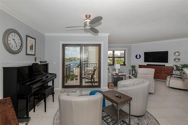 living room featuring ceiling fan, crown molding, a textured ceiling, and light tile patterned flooring