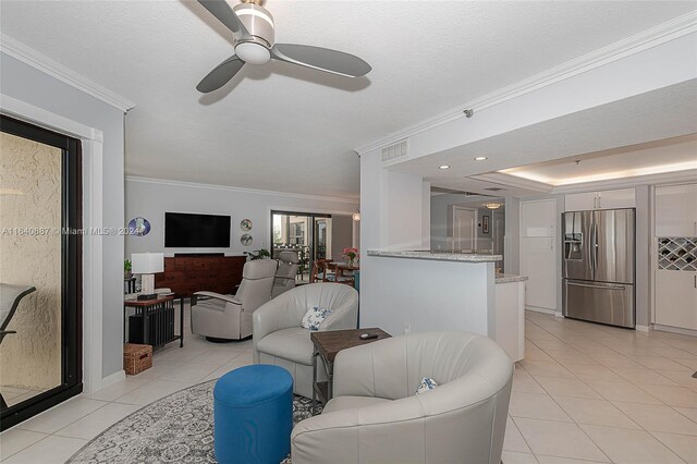 tiled living room featuring ceiling fan and ornamental molding