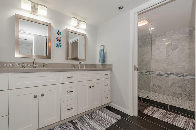 bathroom featuring tile patterned flooring, double vanity, and tiled shower