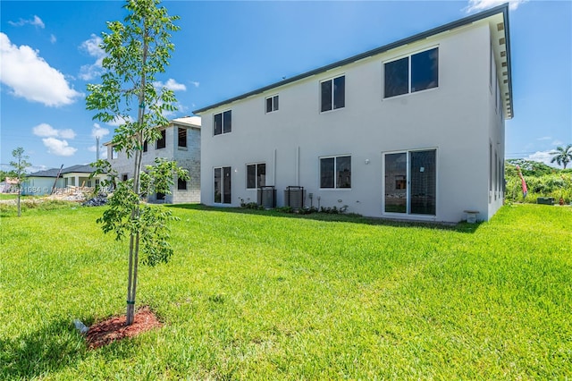 back of property with a lawn and central air condition unit