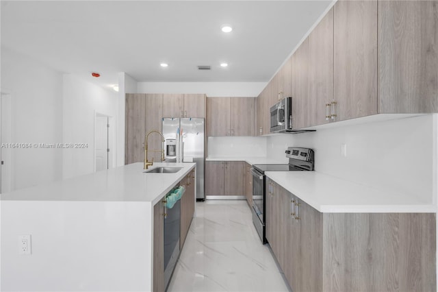 kitchen featuring an island with sink, stainless steel appliances, light brown cabinetry, and light tile patterned floors