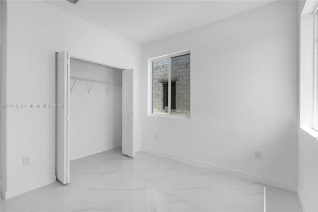 unfurnished bedroom with tile patterned flooring and a closet