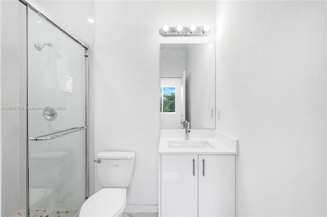 bathroom featuring walk in shower, toilet, and vanity