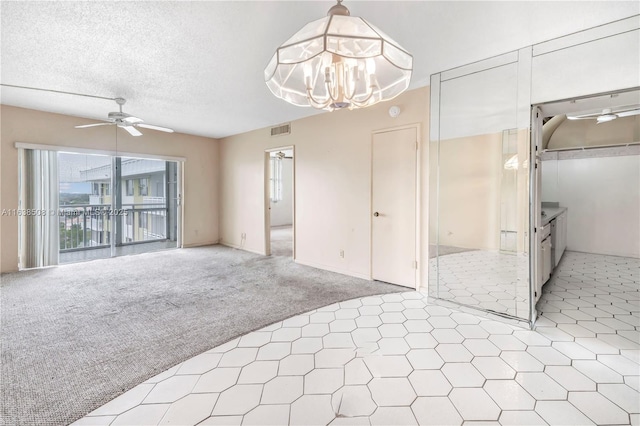 interior space with ceiling fan with notable chandelier, a textured ceiling, and carpet flooring