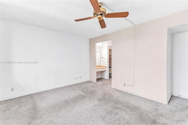 carpeted empty room featuring ceiling fan and a textured ceiling