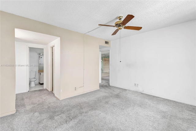 spare room with ceiling fan, light carpet, and a textured ceiling