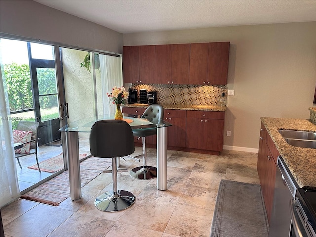 interior space with sink, light stone counters, stainless steel dishwasher, a textured ceiling, and decorative backsplash