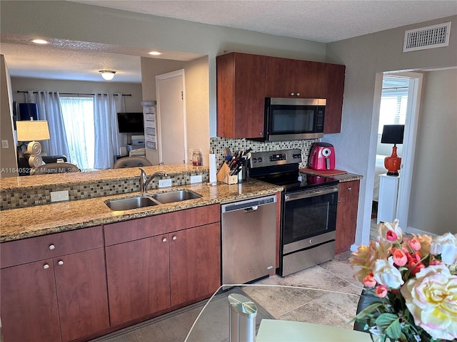 kitchen featuring tasteful backsplash, sink, stainless steel appliances, and a textured ceiling