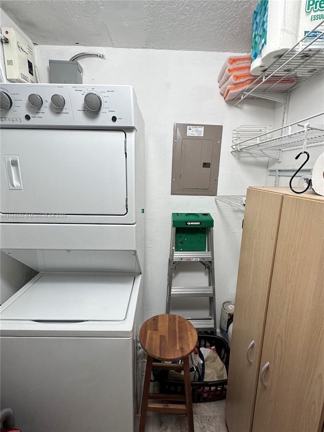 laundry room with a textured ceiling, electric panel, and stacked washer / drying machine