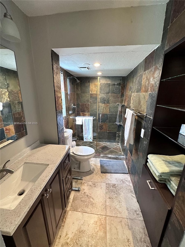 bathroom featuring vanity, toilet, walk in shower, and tile walls