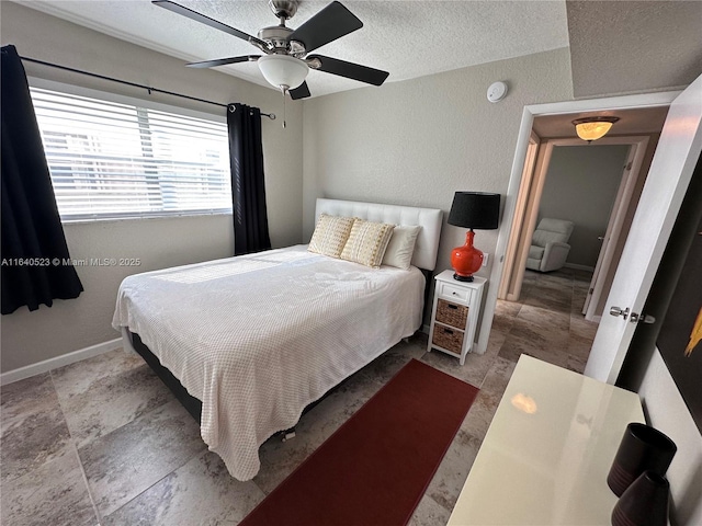 bedroom with ceiling fan and a textured ceiling