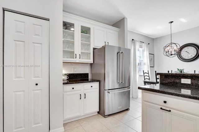 kitchen featuring a chandelier, white cabinetry, high quality fridge, dark stone counters, and pendant lighting