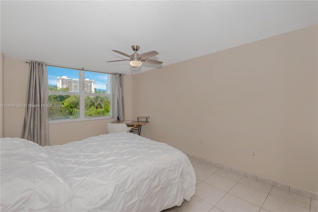 tiled bedroom featuring a textured ceiling and ceiling fan